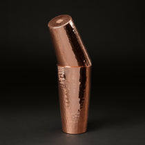 Copper Boston cocktail shaker set with the smaller tin tilted inside the larger one