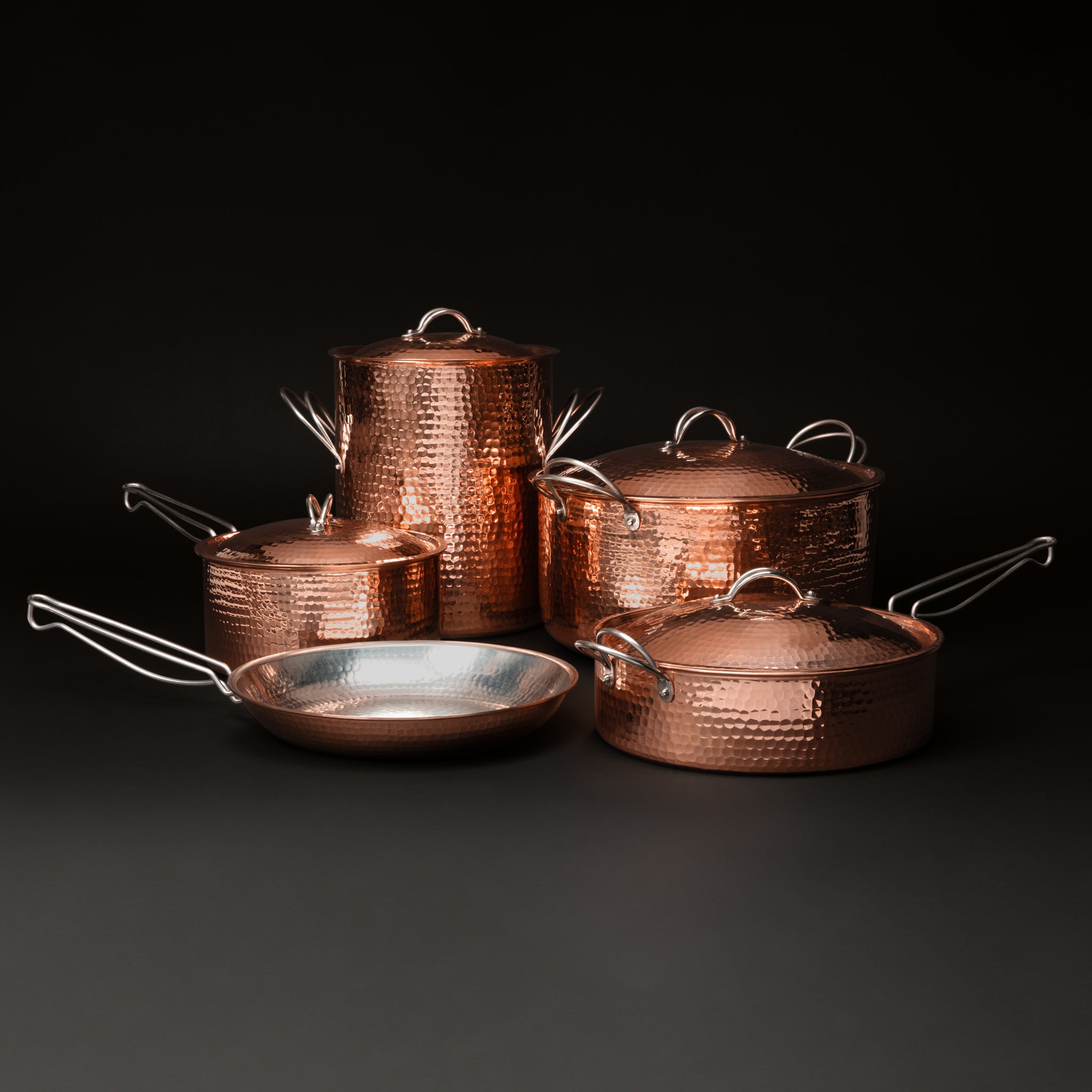 Copper pots and pans set with stock pot, Dutch oven, saucepan, sauté pan, and skillet, lids on